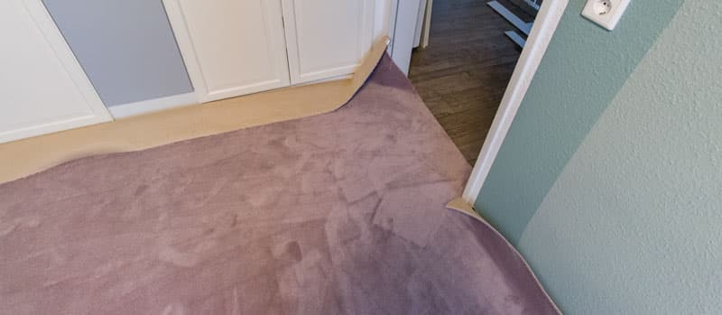 Teppich auf Laminat verlegen - Teppich Überstände wegschneiden